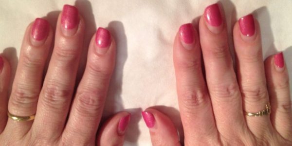 The gel polish manicure following four weeks' growth. The product is nearly half way up the nail bed, which would cause the product to become too top heavy & put too much pressure on the nail plate, potentially leading to damage.