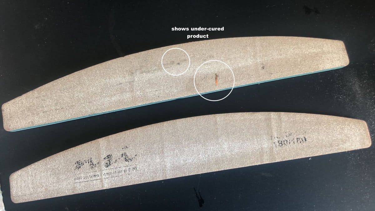 Where the file is grey is where the grit has been worn off. There is little to no grit remaining, meaning the file would have no effect. The circled patches show un-cured gel polish on the file.