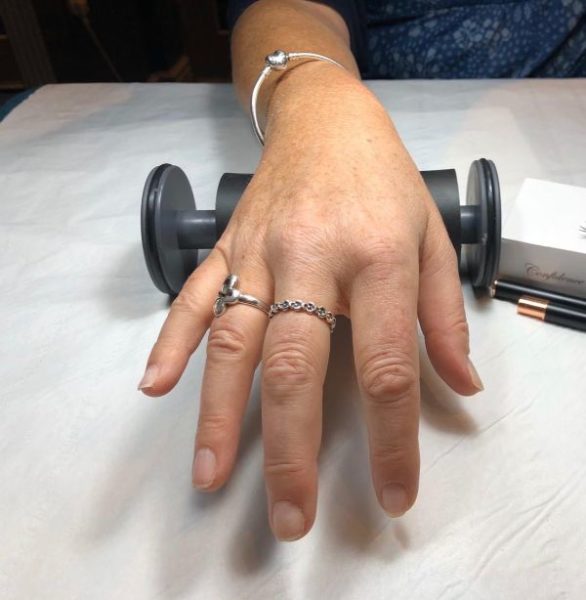 Correct position: The client's hand is straight & directly positioned in front of the tech's body, preventing twisting of the body.