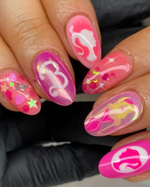 Yan Tee of @yanpaintsnails has fun with the Barbiecore trend, painting glossy Barbie portraits amongst glitter and the iconic 'B'.