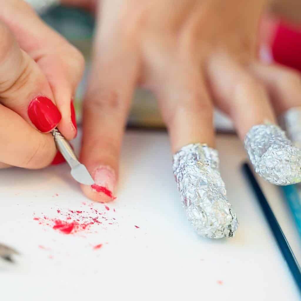 A cuticle pusher gently removes soaked product from the nails.