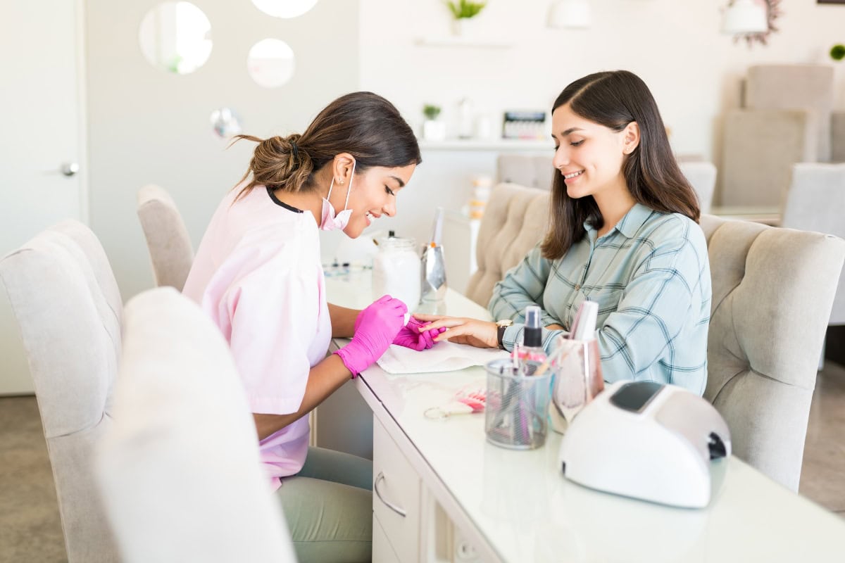 Happy nail technician & salon client