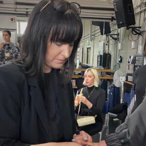 Nail professional styling nails backstage during a session for beauty and salon industry inspiration.